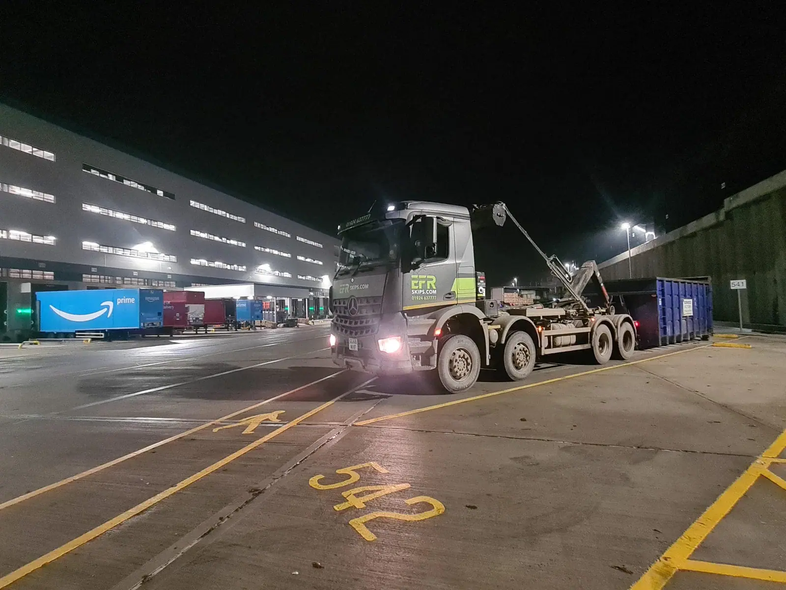 A roll-on-roll-off container positioned in a commercial waste bay